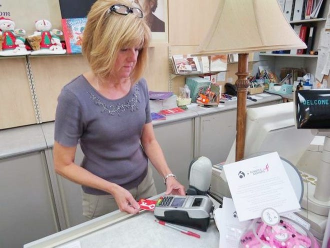 Colozzi's Sales Associate Wendy Cuda uses one of the new chip card readers Thursday afternoon to ring out a customer at the store's New Hartford Shopping Center location. GATEHOUSE NEW YORK PHOTO/PHILIP A. VANNO