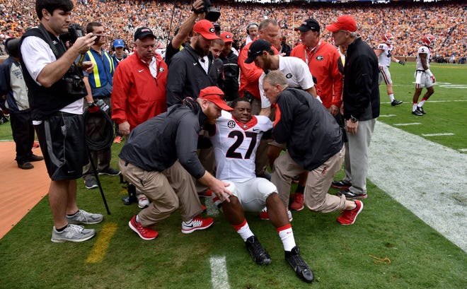 Georgia running back Nick Chubb is helped off the field after injuring his left knee on the first play from scrimmage during an NCAA college football game against Tennessee, Saturday, Oct. 10, 2015, in Knoxville, Tenn.