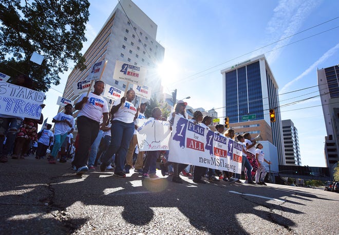 People march in Jackson, Miss., Sunday, Oct. 11, 2015, en route to a change-the-flag rally on the steps of the state Capitol. Civil-rights leader Myrlie Evers-Williams, Mississippi-born rapper David Banner and a prominent South Carolina lawmaker are calling on Mississippi to remove the Confederate battle emblem from its state flag. (Joe Ellis/The Clarion-Ledger via AP)