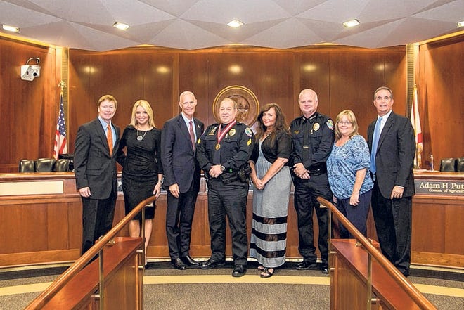 On hand to award Police Sgt. Anthony Kelly with a Medal of Heroism were, from left: Department of Agriculture Commissioner Adam Putnam, Attorney General Pam Bondi, Gov. Rick Scott, Anthony Kelly, wife Kathy Kelly, Mexico Beach Police Chief Glenn Norris, wife Terri Norris and Chief Financial Officer Jeff Atwater.