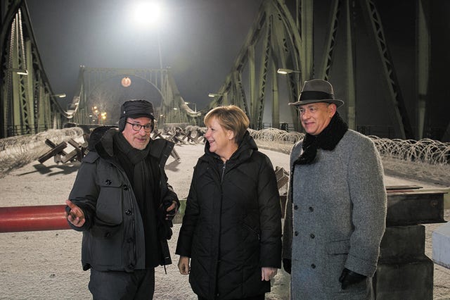 German Chancellor Angela Merkel talks on the set of the Glienicke bridge with director Steven Spielberg, left, and actor Tom Hanks on Nov. 28, 2014, in Berlin. ddp images/Sipa USA