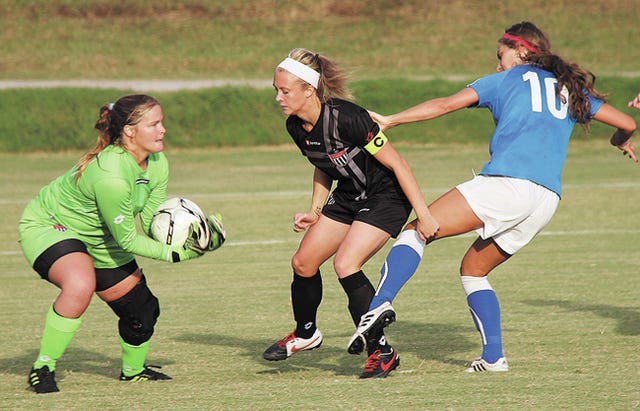Oklahoma Wesleyan University goalie Lindsey Williams, left, makes a save during a home women’s varsity soccer game last month in Bartlesville against Oklahoma City University. OCU pulled out a 3-1 victory. Mike Tupa/Examiner-Enterprise