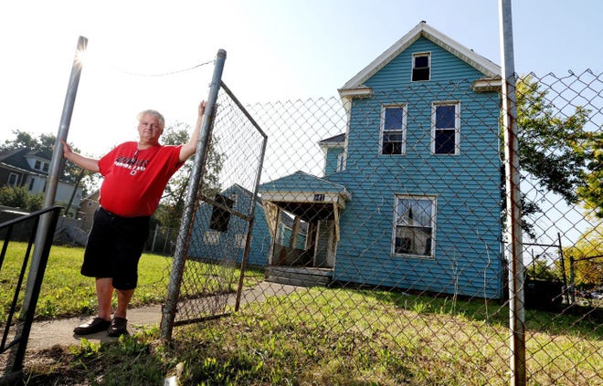 Fred Coons stands in front of the home once owned by his father on Chittenden Avenue in Columbus. His father has passed away, making it difficult for him and the city to deal with the property.