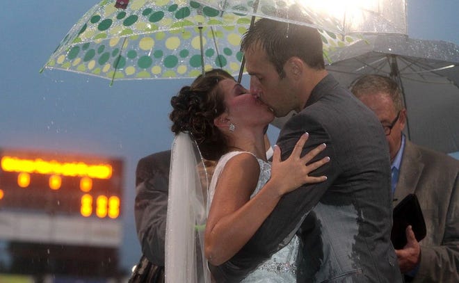 (Photo Mike Hensdill/The Gaston Gazette ) The pouring rain did not postpone the wedding of Grizzlies owner Jesse Cole and Emily McDonald on the ball field at Sims Legion Park Saturday evening, October 10, 2015.