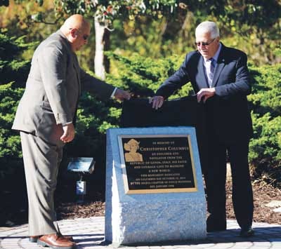Photo by Daniel Freel/New Jersey Herald — Joe Agresti, past president of UNICO national, left, and Ken Carafello, chapter president, unveil a plaque dedicated to Christopher Columbus during a Columbus Day ceremony at Dykstra Park in Sparta on Monday.