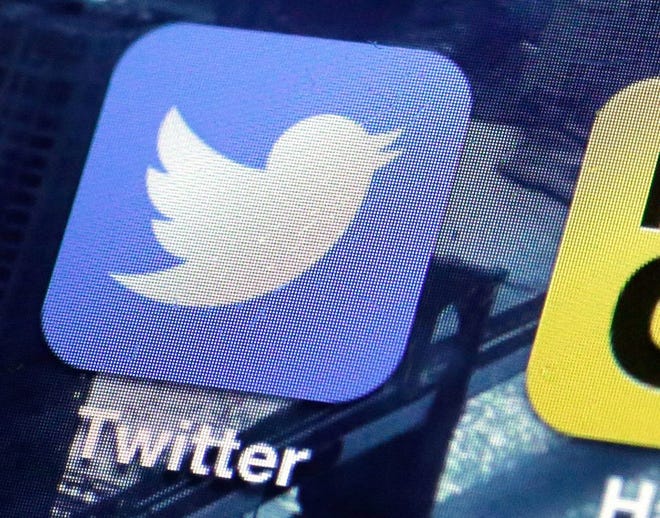 This Friday, Oct. 18, 2013, file photo, shows a Twitter app on an iPhone screen, in New York. Twitter on Tuesday, Oct. 13, 2015 announced the company is laying off up to 336 employees, signaling CEO Jack Dorsey's resolve to slash costs while the company struggles to make money. (AP Photo/Richard Drew, File)