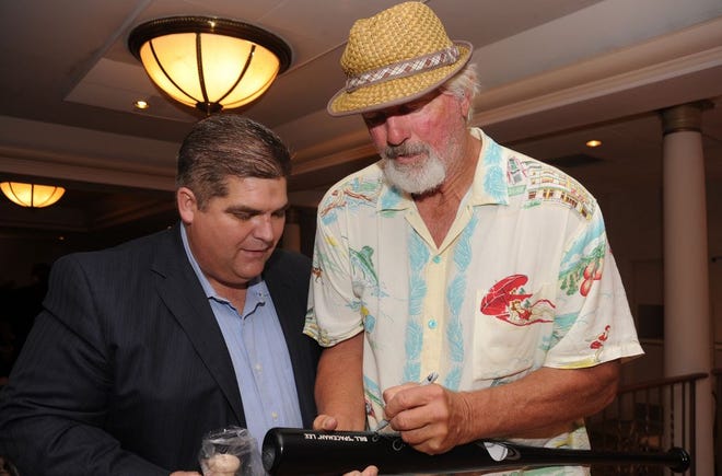 Former Red Sox pitcher Bill "Spaceman" Lee signs a bat for Carl Garcia at the SouthCoast Business Expo Wednesday at White's of Westport.