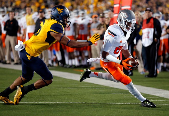 Oklahoma State's Jalen McCleskey (84) rushes as West Virginia's Terrell Chestnut (16) chases him during a college football game between the Oklahoma State Cowboys (OSU) and the West Virginia (WVU) at Milan Puskar Stadium in Morgantown, West Virginia., Saturday, Oct. 9, 2015. OSU won 33- 26 in overtime. Photo by Sarah Phipps, The Oklahoman