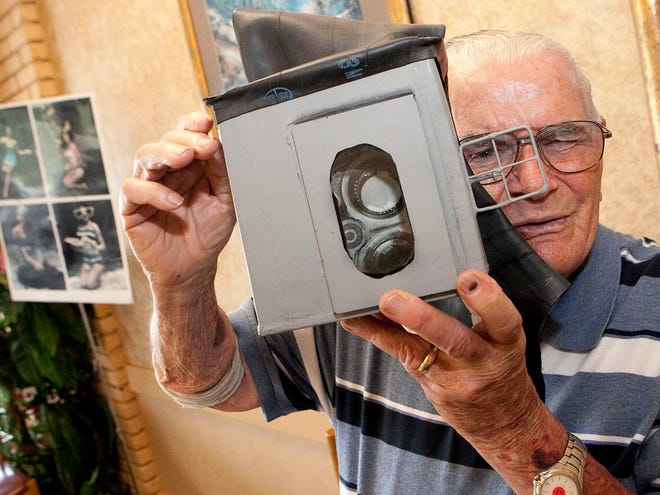 In this Sept. 1, 2010 file photo, Ocala photographer Bruce Mozert holds his first underwater camera housing. Mozert, a pioneer in underwater photography, has died at 98.