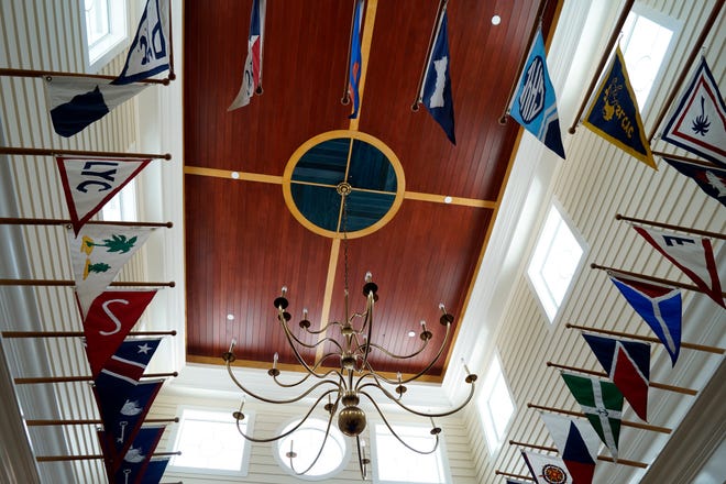 Flags of yacht clubs throughout Florida hang in the foyer of the Bird KeyYacht Club, where the Navy League Council of Sarasota-Manatee will host a dinner to celebrate the 240th birthday of the U.S. Navy.