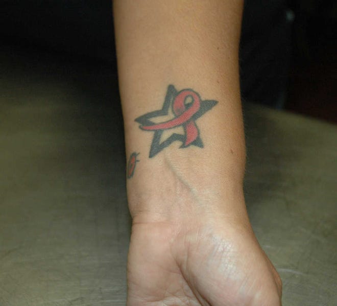 Jessicah Lawrence/Jasper County Sun TimesBreast cancer survivor Rebecca Garcia shows off her pink ribbon tattoo on her wrist. She decided to get the tattoo beside her ladybug tattoo, which symbolizes her mother who lost in the battle against breast cancer.