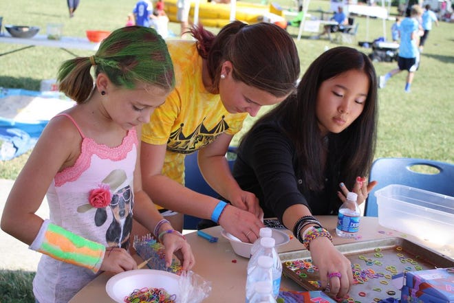 Elizabeth Efird, center, helps with a craft project at last year's Gaston Day School Fall Fest.