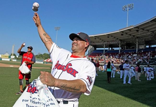 Humberto Quintero and his Pawtucket Red Sox teammates throw soft novelty baseballs to fans after the final game of the season at McCoy Stadium on Monday.