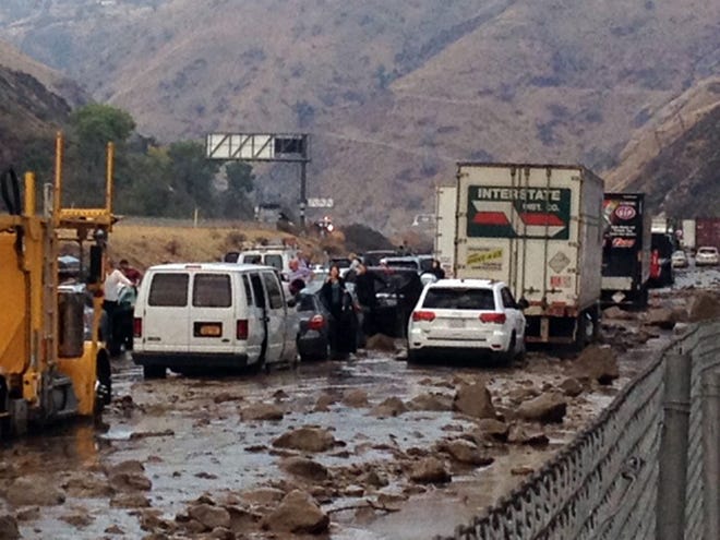 In this photo provided by Caltrans, vehicles are stopped in mud on California's Interstate 5 after flooding Thursday.