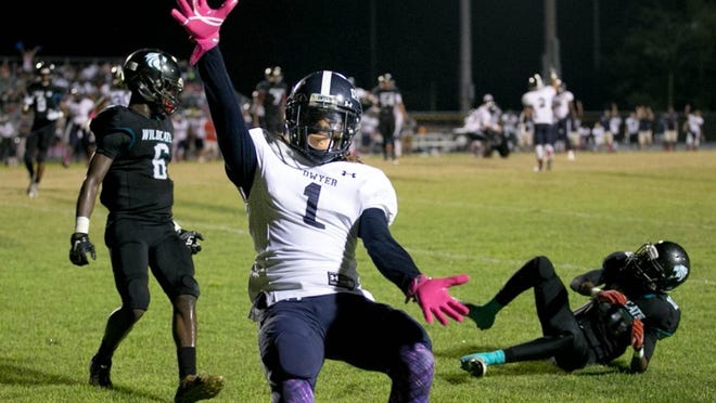 Dwyer wide receiver Oyeh Lurry-Davis (1) celebrates a touchdown in front of Royal Palm Beach defenders Adarius Dent (6) and Ja’Vonte Mosley (10) as the second-ranked Panthers held off the Wildcats 28-27. (Allen Eyestone / The Palm Beach Post)