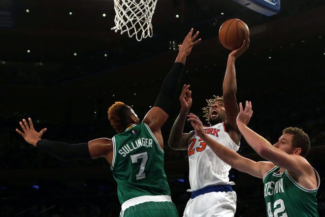 Derrick Williams (23) of the Knicks drives to the basket Boston's Jared Sullinger (7) and David Lee (42) on Friday night in New York.