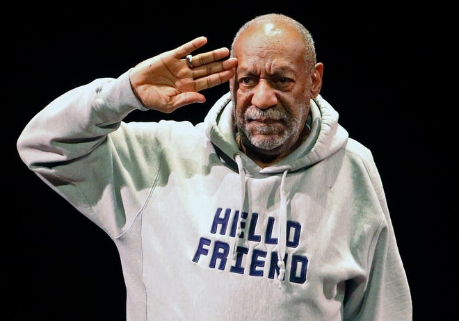 In this Jan. 17, 2015, file photo, comedian Bill Cosby salutes the crowd as he begins a performance at the Buell Theater in Denver. A year after allegations of sexual assault resurfaced and snowballed, women who've accused him of sexual assault are giving emotional interviews en masse, judges are ruling against him and colleges are continuing to revoke honorary degrees bestowed upon him when he was one of the country's most admired entertainers. (AP Photo/Brennan Linsley, File)
