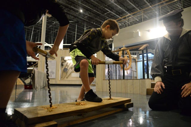 Jonathan McCullough, 8, tries his hand at auguring a plank, much like the CSS Neuse shipbuilders would have, Saturday at the CSS Neuse Interpretive Center on Queen Street in Kinston.