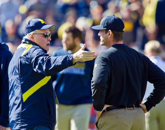 Michigan athletic director Jim Hackett, left, talks with head coach Jim Harbaugh, right, before an NCAA college football game against Northwestern in Ann Arbor, Mich., Saturday, Oct. 10, 2015.