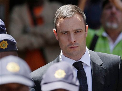 FILE - In this Friday, Oct. 17, 2014 file photo, Oscar Pistorius is escorted by police officers as he leaves the high court in Pretoria, South Africa. A South African official says Oscar Pistorius has been released from prison and placed under house arrest. Manelisi Wolela, a spokesman for South Africa's correctional services department, said the double-amputee Olympic runner who fatally shot his girlfriend on Valentine's Day 2013 was put under "correctional supervision" late on Monday, Oct. 19, 2015. (AP Photo/Themba Hadebe, File)