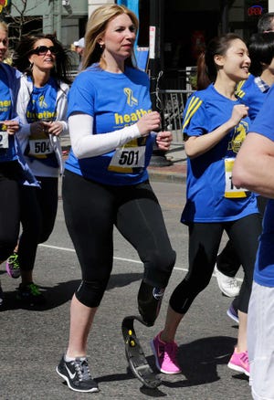 Boston Marathon bombing survivor Heather Abbott, center, dashes from the start line on her running blade in April 2014 during the Tribute Run during Boston Marathon weekend in Boston.AP file photo