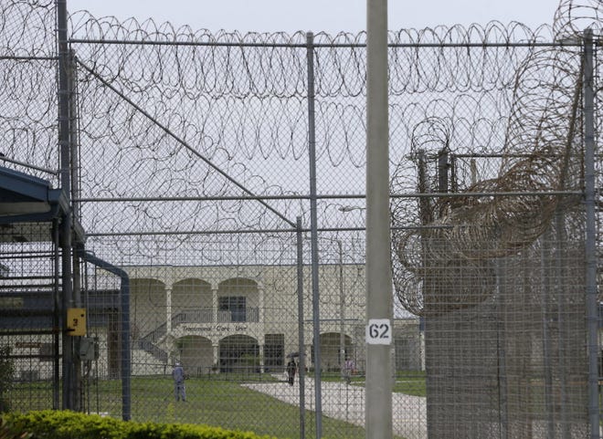 A prisoner works on the lawn at the Dade Correctional Institution.