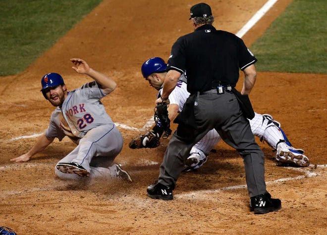 New York Mets' Daniel Murphy scores past Chicago Cubs catcher Miguel Montero during the seventh inning of Game 3 of the National League baseball championship series Tuesday, Oct. 20, 2015, in Chicago. Murphy scored from third on a ball hit by Lucas Duda. (AP Photo/Charles Rex Arbogast)