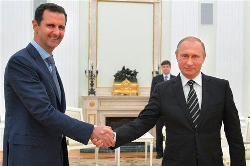 In this photo taken on Tuesday, Oct. 20, 2015, Russian President Vladimir Putin, right, shakes hand with Syria President Bashar Assad in the Kremlin in Moscow, Russia. Assad has traveled to Moscow in his first known trip abroad since the war broke out in Syria in 2011 to meet his strongest ally Russian leader Vladimir Putin, Syrian and Russian media reported Wednesday. (Alexei Druzhinin, RIA-Novosti, Kremlin Pool Photo via AP)