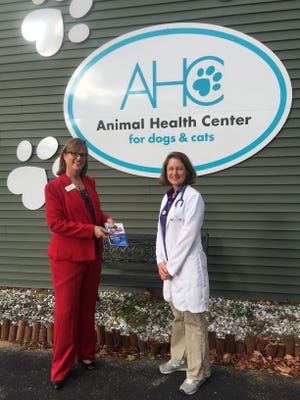 Sharla Rollins, branch manager of the Rochester Federal Savings Bank, delivers the new business directory to the Animal Health Center. Courtesy photo