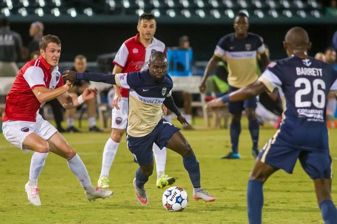 Fran Ruchalski for the Times-Union The Armada's Pascal Millien (center) brings the ball up field in the first half against the Ottawa Fury on Wednesday at the Baseball Grounds of Jacksonville.