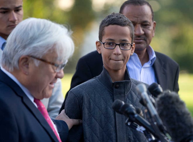 Ahmed Mohamed, second from right, listens as Rep. Mike Honda, D-Calif., left, speaks during a news conference on Capitol Hill in Washington, Tuesday, Oct. 20, 2015. Mohamed is the 14-year-old "clock kid", freshman, who was arrested in Irving, Texas, for bringing an alarm clock science project to his high school teacher. To the far right is Ahmed's uncle Aldean Mohamed. (AP Photo/Carolyn Kaster)