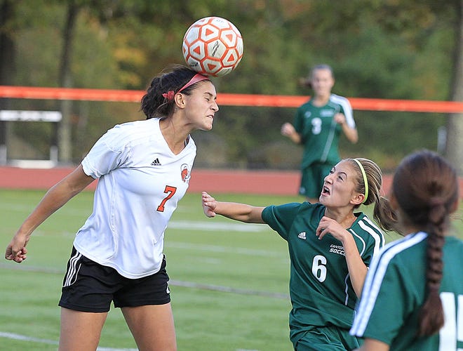 Oliver Ames' Francesca Calabraro, left, heads the ball downfield over Canton players in the first half at Oliver Ames on Tuesday, Oct. 20, 2015.