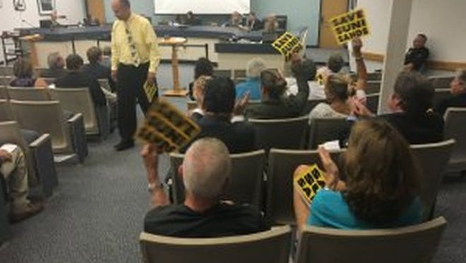 Suni Sands residents hold up signs at Tuesday night Jupiter Council meeting (Photo by Bill DiPaolo)