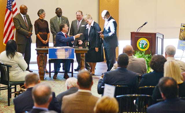 Governor Pat McCrory talks with Deborah Grimes, vice president of curriculum at Lenoir Community College, state legislators and North Carolina Governor's Board members after he signs the Connect NC bond initiative at Lenoir Community College.