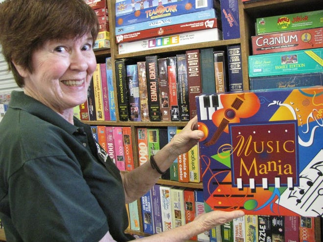 Sue Dudley, chair of publicity for the Friends of the Library, displays one of the many types of family-friendly games that can be found at the Fall Book Sale, which kicks off Saturday.
