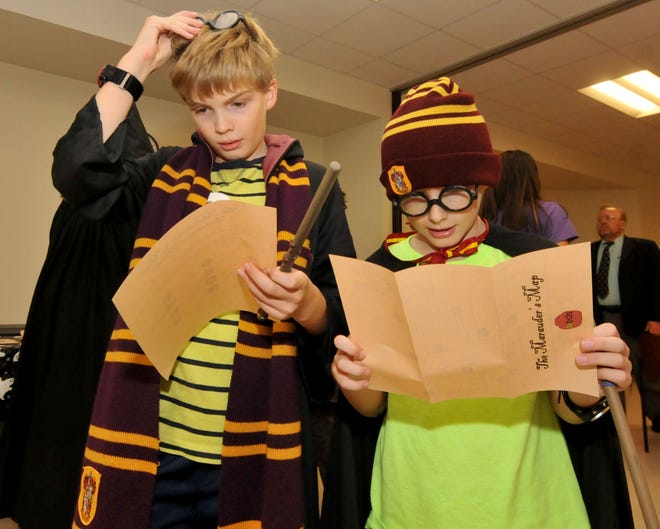 Bryce Svensen, 10, and Brayden Svensen, 7, of Medford, look at a map to help them through a scavenger hunt at Harry's Magical House Party at the Burlington County Library  in Westampton on Thursday, Oct. 22, 2015.