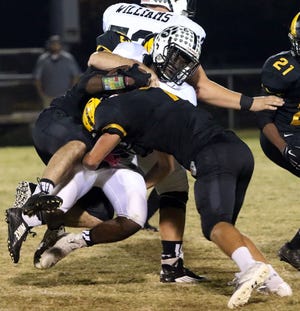 Chesnee's Seth Blanton (45) and Reece Blackwood (7) bring down Blacksburg's Isaiah Burris during the first half of Friday night's game. MIKE BONNER/For the Herald-Journal.