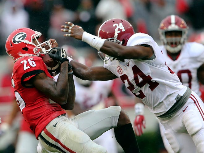 Georgia wide receiver Malcolm Mitchell (26) makes a catch as Alabama defensive back Geno Matias-Smith (24) defends in the first half of a college football game, Saturday, Oct. 3, 2015, in Athens, Ga.