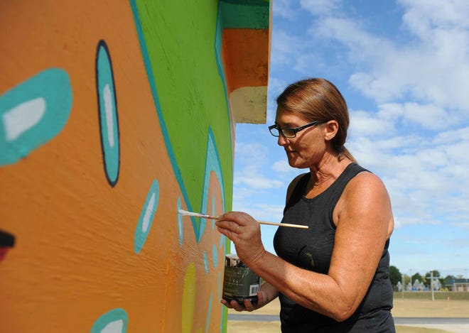 Debbie Lewis continues to paint her mural "Always on my mind" Friday, Oct. 23, 2015 at the skatepark in Palmore Park.