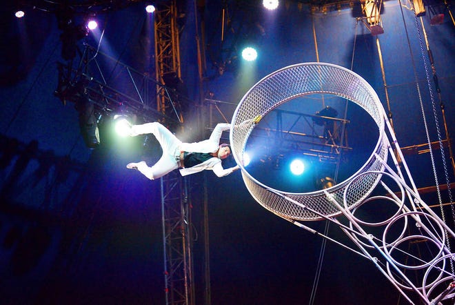 A performer flies through the air at one end of the Navas wheel at the UniverSoul Circus.
