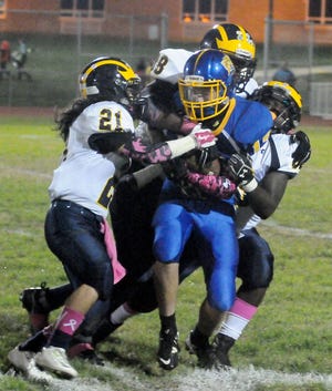 Maple Shade's Carlos Ortiz (13) gets tackled by Florence's Joey Lee (21), Marcus Crowell (88) and Jajuan Hays (33) during a football game at Maple Shade High School Friday, Oct. 23, 2015.