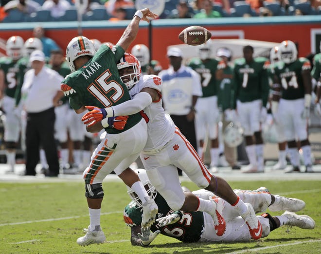 Clemson defensive end Kevin Dodd tackles Miami quarterback Brad Kaaya (15) as he passes during the first half of Saturday's game in Miami Gardens, Fla. WILFREDO LEE/AP