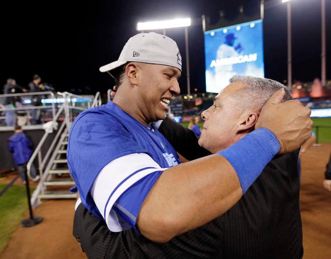 Kansas City Royals general manager Dayton Moore, right, embraces catcher Salvador Perez after Friday's 4-3 ALCS-clinching victory over the Toronto Blue Jays. Moore has been with the Royals since 2006.