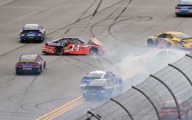 Tony Stewart (14) crashes with Denny Hamlin (11), Austin Dillon (3), Jimmie Johnson (48) and others on a restart attempt in the final laps of the NASCAR Sprint Cup Series auto race at Talladega Superspeedway, Sunday, Oct. 25, 2015, in Talladega, Ala. (AP Photo/ Mark Almond)
