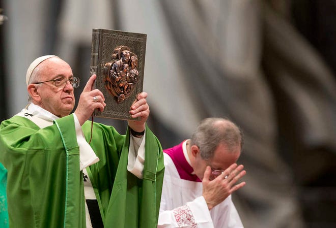 Pope Francis holds the Gospel Book as he celebrates a Mass to mark the end of the Synod of bishops, in St.Peter's Basilica at the Vatican, Sunday, Oct. 25, 2015. Catholic bishops called Saturday for a more welcoming church for cohabitating couples, gays and Catholics who have divorced and civilly remarried, endorsing Pope Francis' call for a more merciful and less judgmental church. (AP Photo/Alessandra Tarantino)