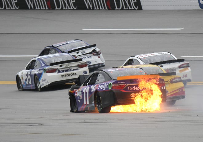 Sprint Cup Series driver Denny Hamlin (11) brings his burning car to a stop after being involved in a crash during the official GWC attempt in the NASCAR Sprint Cup Series auto race at Talladega Superspeedway Sunday, Oct. 25, 2015, in Talladega, Ala. (AP Photo/Russell Norris)