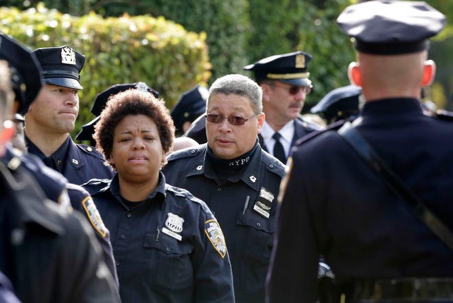 New York police officers arrive for the wake of fellow officer Randolph Holder at the Greater Allen A.M.E. Cathedral, Tuesday, Oct. 27, 2015, in the Queens borough of New York. Holder was shot and killed Tuesday, Oct. 20 while pursuing a suspect in the Harlem neighborhood of New York. The suspect was caught several blocks away with a gunshot wound to his leg. (AP Photo/Mark Lennihan)