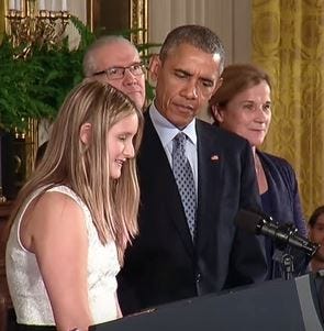 President Barack Obama listens as Ayla Ludlow of Pembroke gives the opening remarks at a reception for the World Cup champion U.S. women's national soccer team at the White House on Tuesday, Oct. 27, 2015.