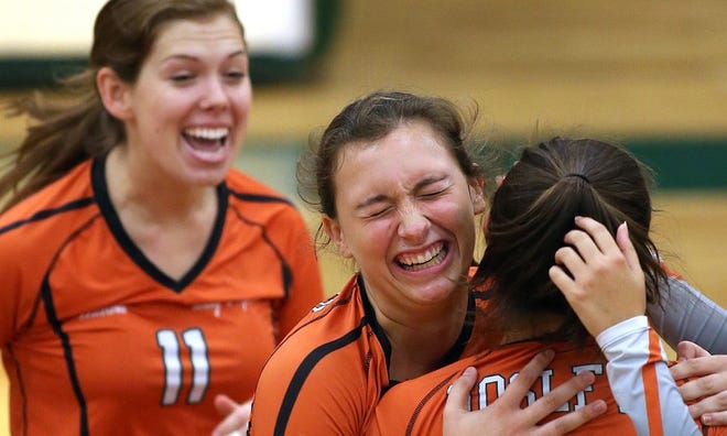 Mosley’s Camryn May (11), Savannah Stanton, middle, and Maddy Iferd celebrate after a point during the Lady Dolphins’ playoff match against Suwannee.