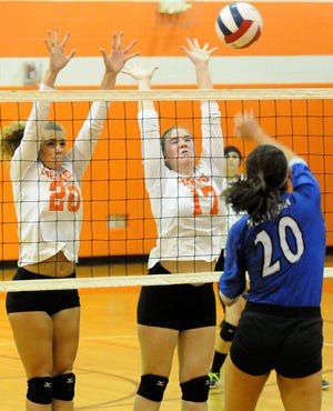 Cherokee's Samantha Debicki (20) and Elizabeth Chambers (17) defend a ball from Northern Burlington's Emily Konopka (20) during a volleyball game at Cherokee High School Wednesday evening.